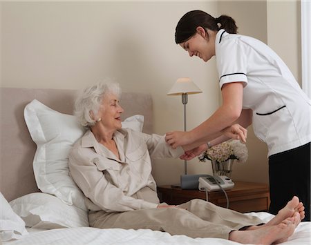 Nurse rolling up elderly woman's sleeve Stock Photo - Premium Royalty-Free, Code: 649-03292163