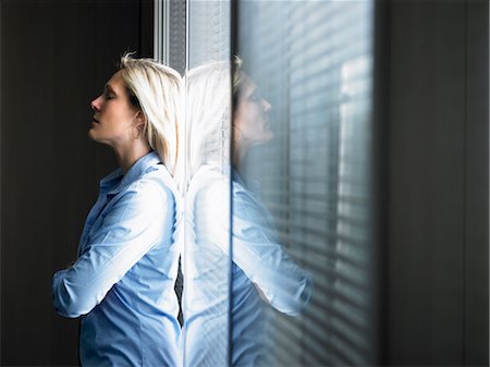 Woman against window, thinking Stock Photo - Premium Royalty-Free, Code: 649-03292277