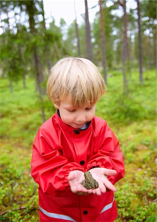 rain coat for boys - Toddler holding frog in forest Stock Photo - Premium Royalty-Free, Code: 649-03292644