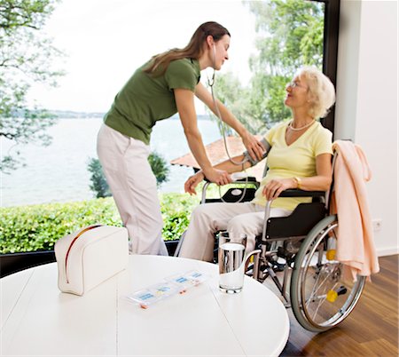 senior care inside assistance - nurse taking woman's blood pressure Stock Photo - Premium Royalty-Free, Code: 649-03292667