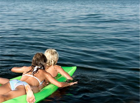 preteen girl swimsuit rear view - Girls on inflatable mattress Stock Photo - Premium Royalty-Free, Code: 649-03292874