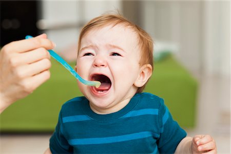 sad family - crying baby sitting in chair being fed Stock Photo - Premium Royalty-Free, Code: 649-03362702