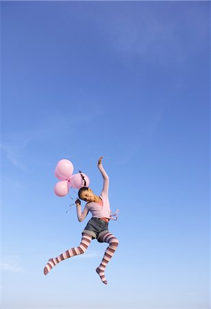 Girl jumping in the air with balloons Stock Photo - Premium Royalty-Free, Code: 649-03362734