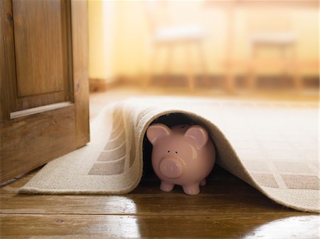 Piggy bank under rug Stock Photo - Premium Royalty-Free, Code: 649-03362870