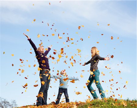 free fall - woman, boy and girl throw autumn leaves Stock Photo - Premium Royalty-Free, Code: 649-03362916