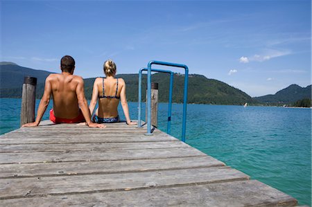 simsearch:6113-07147092,k - A couple sitting on a pier by a lake Fotografie stock - Premium Royalty-Free, Codice: 649-03363185