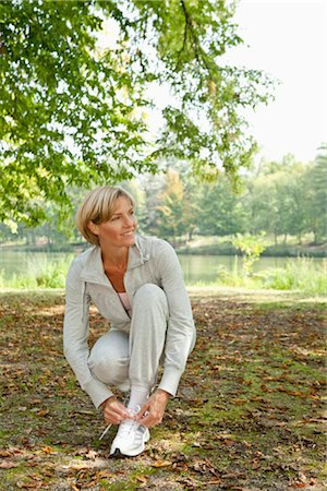 Middle aged woman tying her jogging shoe Foto de stock - Sin royalties Premium, Código: 649-03363278