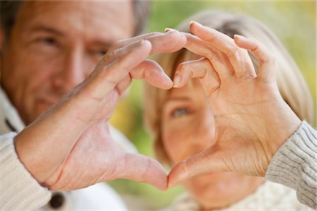 Couple forming heart with their fingers Foto de stock - Sin royalties Premium, Código: 649-03363292