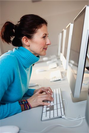 woman sitting at terminal typing Stock Photo - Premium Royalty-Free, Code: 649-03363544