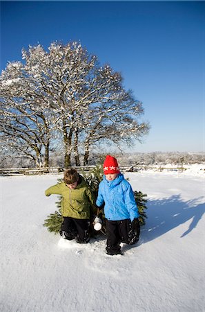 friends christmas - Children pulling christmas tree in snow Stock Photo - Premium Royalty-Free, Code: 649-03417269