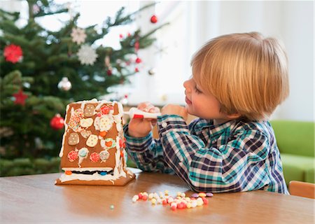 boy decorating gingerbread house Fotografie stock - Premium Royalty-Free, Codice: 649-03417642