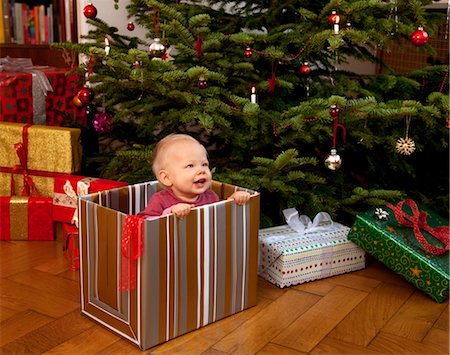 baby playing inside christmas present Stock Photo - Premium Royalty-Free, Code: 649-03417650