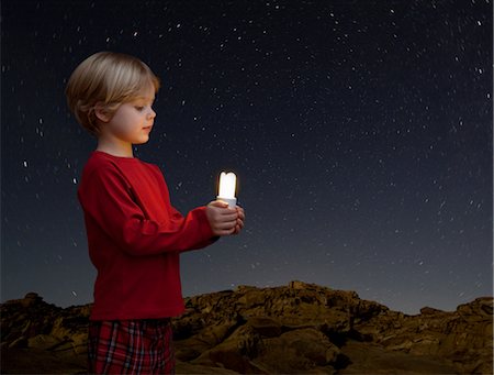 future of lighting - boy with energy saving light bulb Stock Photo - Premium Royalty-Free, Code: 649-03417674