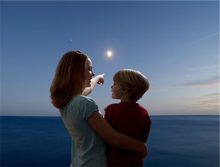 boy and girl watching the moon rising Foto de stock - Sin royalties Premium, Código: 649-03417677