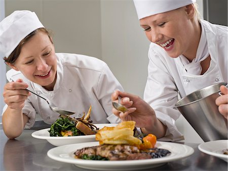 Two female chefs finish some dinners Fotografie stock - Premium Royalty-Free, Codice: 649-03418394