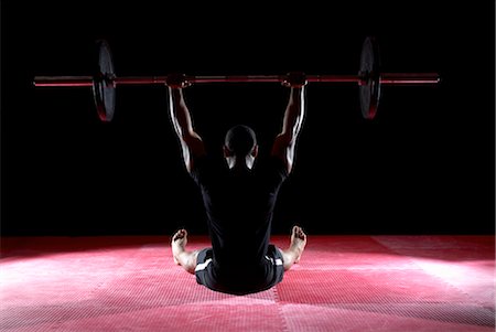 dumbbell man - man lifting weight bar whilst sitting Stock Photo - Premium Royalty-Free, Code: 649-03418416