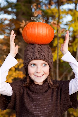 Girl balancing a pumpkin on her head Stock Photo - Premium Royalty-Free, Code: 649-03418528