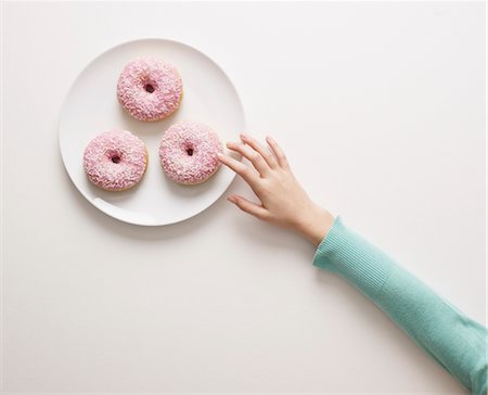 plate cut out - Hand reaching for a doughnut Stock Photo - Premium Royalty-Free, Code: 649-03418690