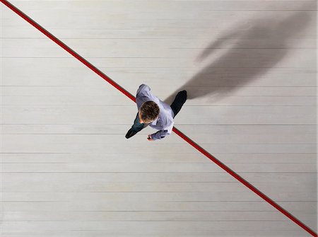 promoting - Business man stepping over a red line Stock Photo - Premium Royalty-Free, Code: 649-03446902