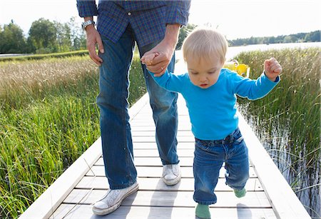 father and son walking hand in hand - Firsts steps of a baby boy Stock Photo - Premium Royalty-Free, Code: 649-03447616