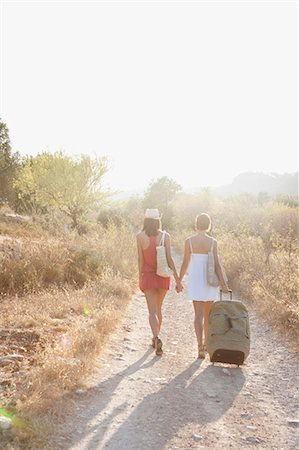 simsearch:614-05557095,k - Two women pulling suitcases along a lane Stock Photo - Premium Royalty-Free, Code: 649-03447917