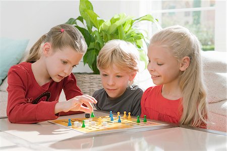 Three children playing a board game Stock Photo - Premium Royalty-Free, Code: 649-03447942