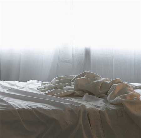 Unmade bed in morning light Foto de stock - Royalty Free Premium, Número: 649-03448340