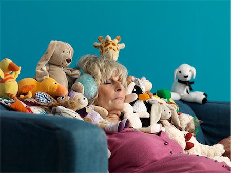 Mature woman asleep surrounded by toys Stock Photo - Premium Royalty-Free, Code: 649-03465609