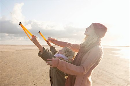 Mother and daughter flying kite on beach Foto de stock - Sin royalties Premium, Código: 649-03466254
