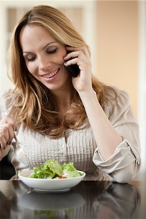 simsearch:649-03291674,k - Woman on cellphone eating salad Stock Photo - Premium Royalty-Free, Code: 649-03486916
