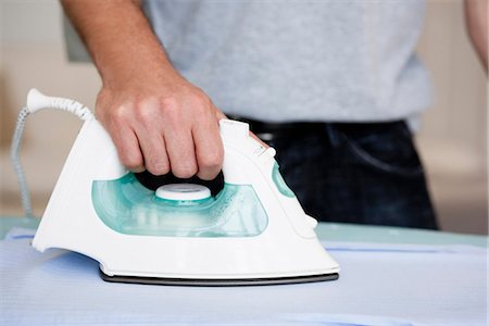 ferro de passar roupas - Man ironing close-up Foto de stock - Royalty Free Premium, Número: 649-03486949