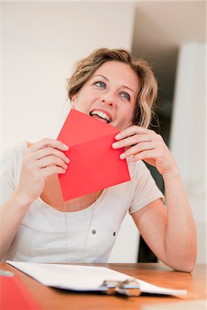 envelope (package) - Woman licking on red envelope Stock Photo - Premium Royalty-Free, Code: 649-03487036