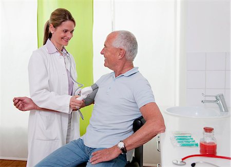 Doctor  patient's taking blood pressure Stock Photo - Premium Royalty-Free, Code: 649-03487200