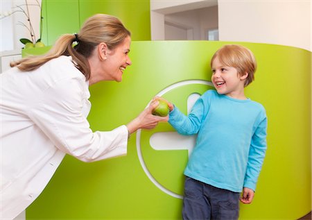 sonrisas sardónicas - Doctor giving apple to boy Foto de stock - Sin royalties Premium, Código: 649-03487217