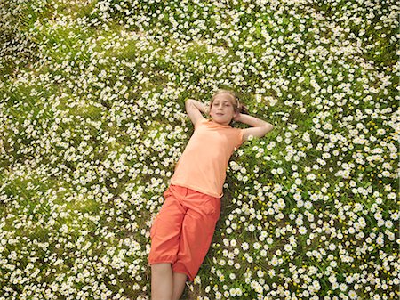 Child lying in field of daisies Stock Photo - Premium Royalty-Free, Code: 649-03487654