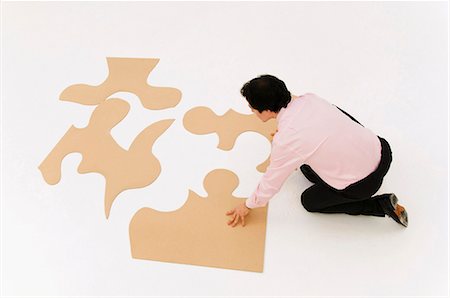 enigma - Business man looks to finish puzzle Foto de stock - Sin royalties Premium, Código: 649-03487794