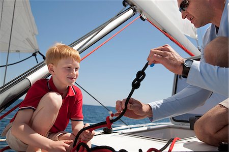Man teaching boy knot on yacht Stock Photo - Premium Royalty-Free, Code: 649-03510980