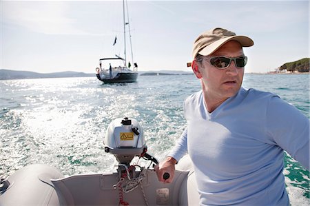 Man steering yacht dinghy Foto de stock - Sin royalties Premium, Código: 649-03510992