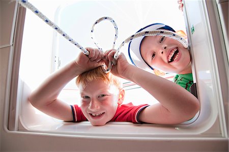 Two boys playing with hatch on yacht Fotografie stock - Premium Royalty-Free, Codice: 649-03511006