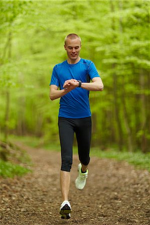 sincronizar - Man running, looking at sports watch Foto de stock - Royalty Free Premium, Número: 649-03511148