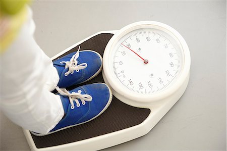 pesandose - Child's feet on scales Foto de stock - Sin royalties Premium, Código: 649-03566537