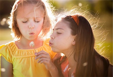 2 girls blowing on dandelion Stock Photo - Premium Royalty-Free, Code: 649-03566625