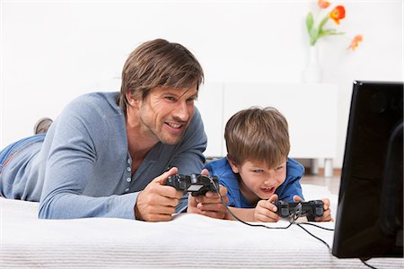 family playing games indoors - Father and son playing a video game Stock Photo - Premium Royalty-Free, Code: 649-03606623