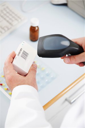 Pharmacist scanning pill box Fotografie stock - Premium Royalty-Free, Codice: 649-03621590