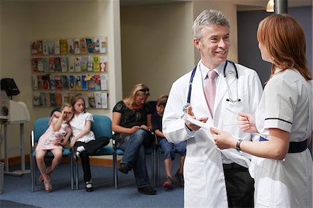 doctors reviewing medical records - Médecin et une infirmière en salle d'attente Photographie de stock - Premium Libres de Droits, Code: 649-03621619