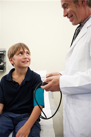 simsearch:649-08118733,k - Doctor taking young boy's blood pressure Foto de stock - Royalty Free Premium, Número: 649-03621626