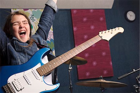 Young girl playing guitar in studio Foto de stock - Sin royalties Premium, Código: 649-03621847