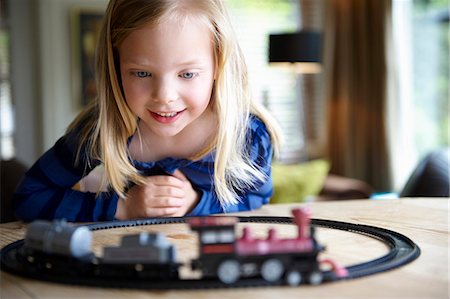 Girl playing with toy train Stock Photo - Premium Royalty-Free, Code: 649-03621901