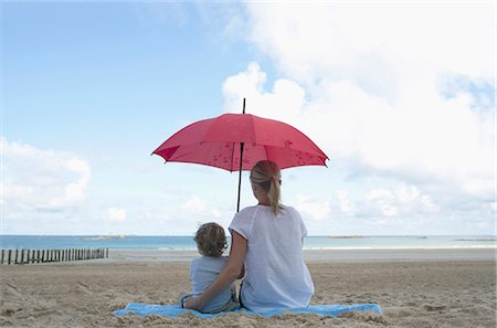 family shelter - Woman and son under a parasol Stock Photo - Premium Royalty-Free, Code: 649-03622286