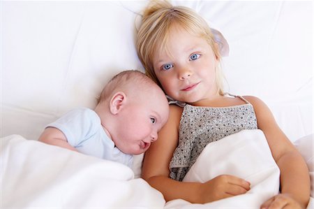 family laying in bed together - Girl with her baby brother in bed Stock Photo - Premium Royalty-Free, Code: 649-03666310